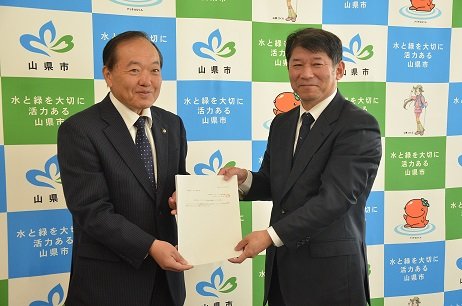 市長へ答申書を手渡す竹内治彦会長の画像