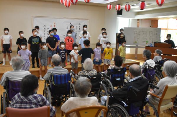 児童と施設利用者がふるさとを一緒にふるさとを歌う